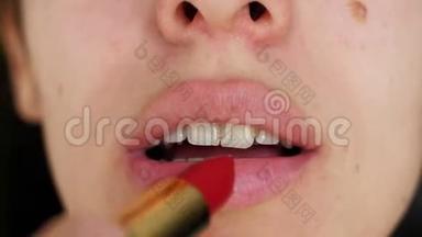 美丽的女孩的肖像，她用鲜红的口红在嘴唇上嘴唇。 年轻女人用红唇做的唇